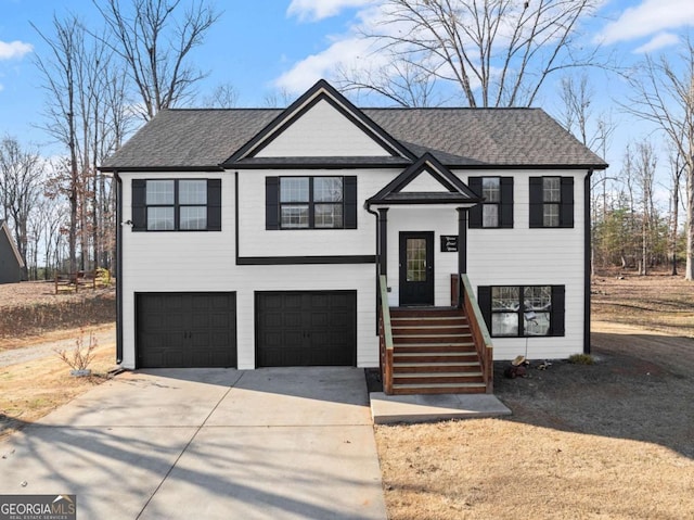 bi-level home with a shingled roof, driveway, and an attached garage