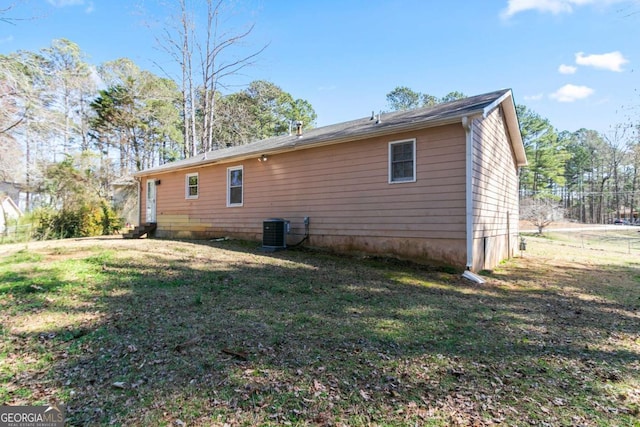 rear view of property with a yard and central AC unit