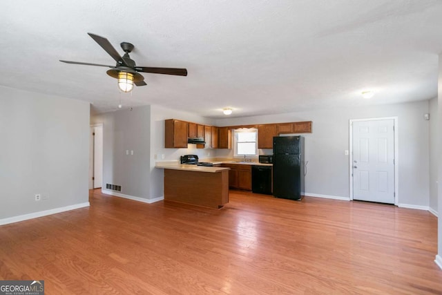 37 Indian Hills Ct, Dallas, GA 30157 - kitchen with black appliances, brown cabinetry, light wood-style floors, a ceiling fan, and light countertops