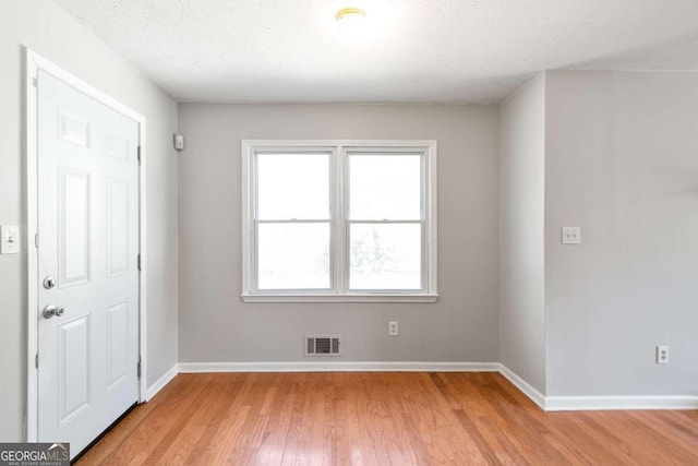 entryway with light wood-type flooring, visible vents, and baseboards