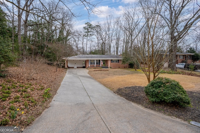 single story home with driveway, crawl space, a front yard, a carport, and brick siding