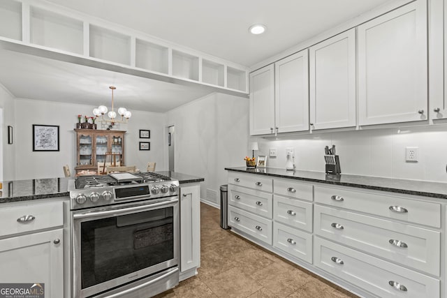 kitchen with dark stone countertops, decorative light fixtures, an inviting chandelier, stainless steel range with gas cooktop, and white cabinetry