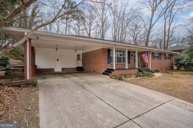 ranch-style house featuring brick siding, concrete driveway, entry steps, crawl space, and an attached carport