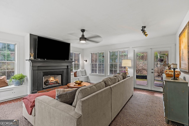 living room with a fireplace with flush hearth and a ceiling fan