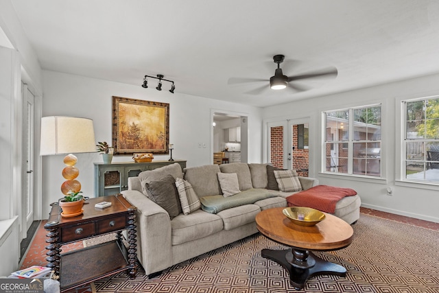 living area featuring ceiling fan, baseboards, track lighting, and french doors