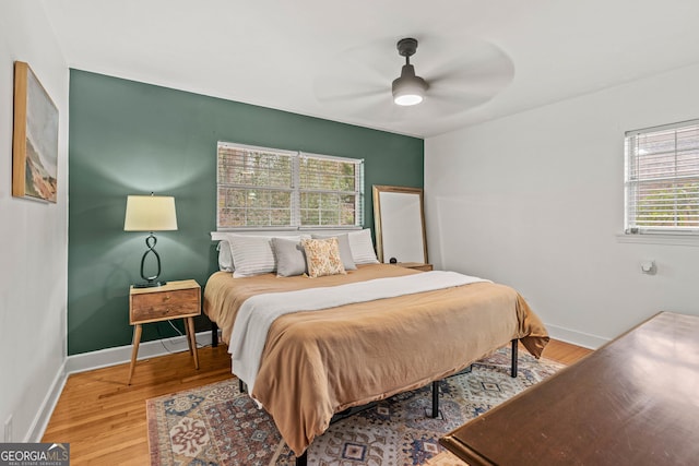 bedroom with ceiling fan, baseboards, and wood finished floors