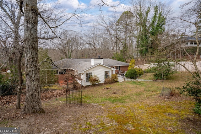 view of front facade featuring a chimney and fence