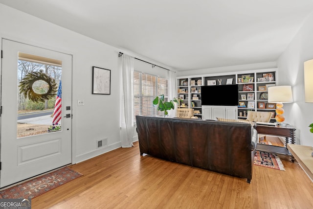 office area with wood finished floors, visible vents, and baseboards