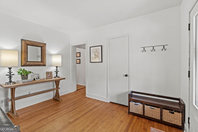 hallway featuring baseboards and light wood finished floors