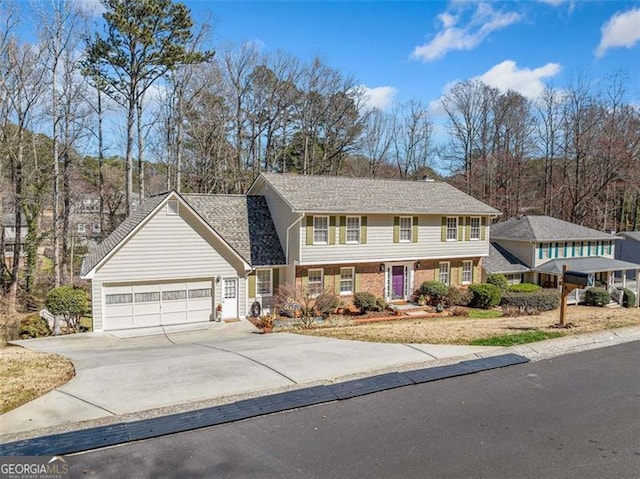 colonial inspired home with an attached garage, driveway, and brick siding