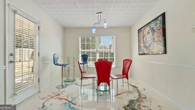 dining area with baseboards and a textured ceiling