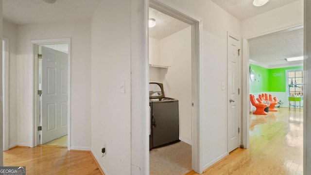 corridor with light wood-style flooring and baseboards