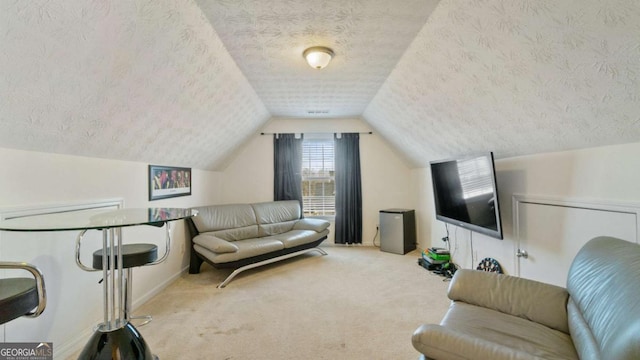 carpeted living area featuring vaulted ceiling and a textured ceiling