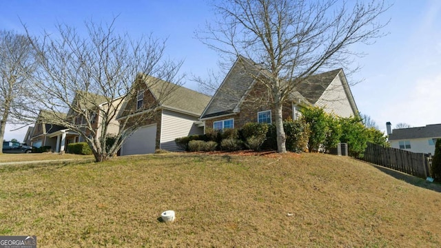 view of front of home with an attached garage, a front yard, and fence