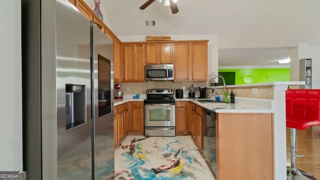 kitchen with light countertops, visible vents, appliances with stainless steel finishes, a sink, and a peninsula