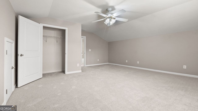 unfurnished bedroom featuring baseboards, light carpet, and lofted ceiling