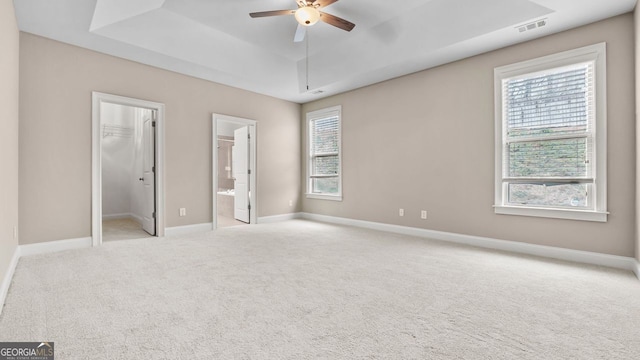 unfurnished bedroom with carpet flooring, visible vents, multiple windows, and a spacious closet