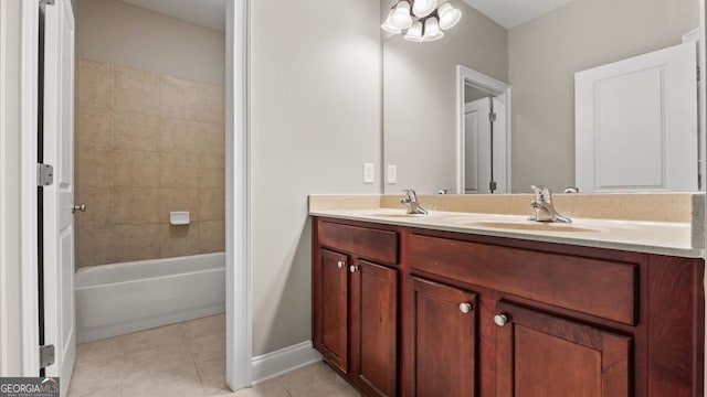 bathroom featuring tile patterned floors, baseboards, double vanity, and a sink