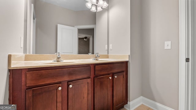 bathroom featuring baseboards, double vanity, and a sink