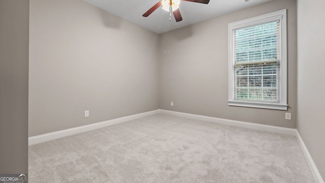 carpeted spare room with baseboards and ceiling fan