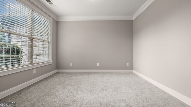 carpeted spare room with crown molding, visible vents, and baseboards