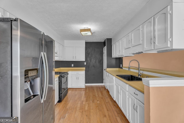 kitchen with light wood-type flooring, black range with electric cooktop, white cabinetry, stainless steel refrigerator with ice dispenser, and a sink