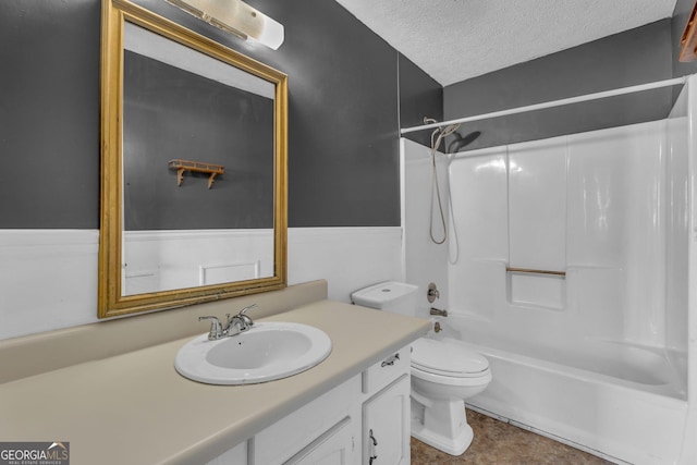 full bath featuring bathtub / shower combination, a textured ceiling, toilet, and vanity