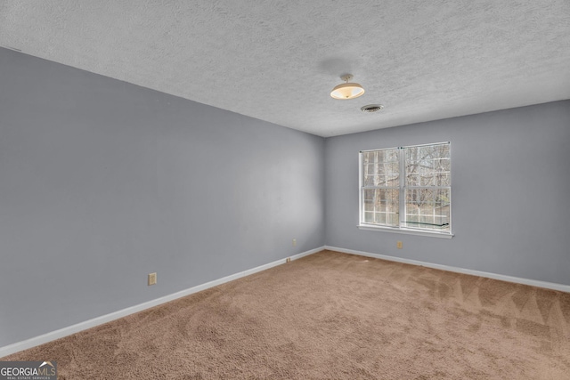 unfurnished room featuring a textured ceiling, carpet floors, visible vents, and baseboards