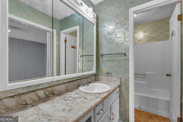 bathroom featuring vanity, a bathing tub, and wallpapered walls