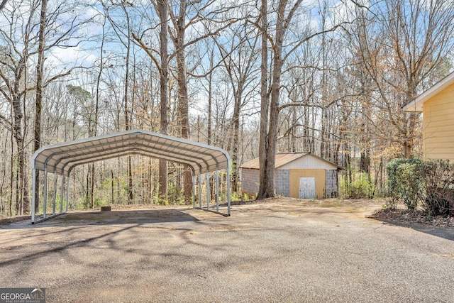 view of parking / parking lot featuring aphalt driveway and a detached carport