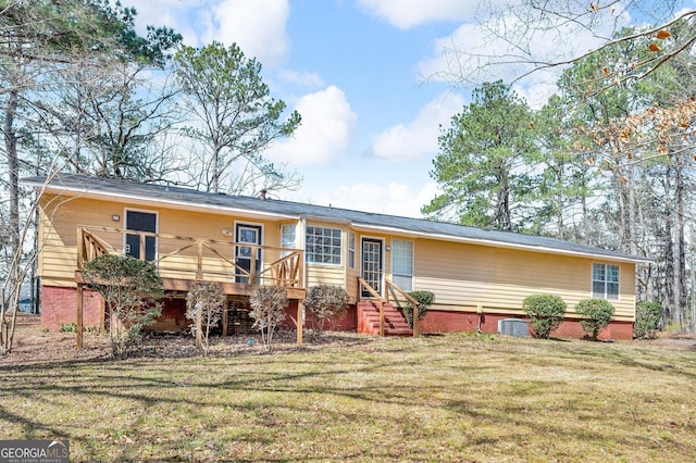 view of front of property with central AC unit, entry steps, crawl space, a deck, and a front lawn