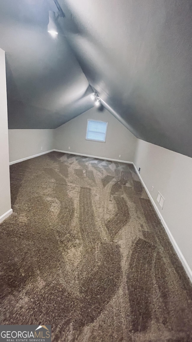 bonus room with baseboards, vaulted ceiling, and carpet flooring