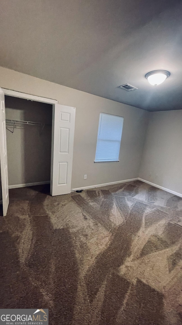 unfurnished bedroom with carpet flooring, visible vents, and baseboards