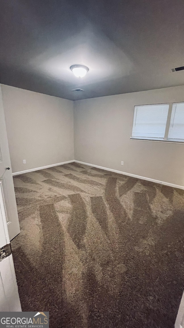 carpeted empty room featuring visible vents and baseboards