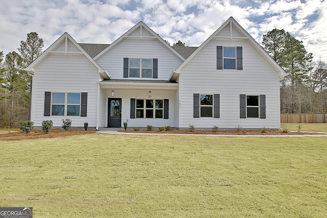 view of front of property featuring a front lawn and roof with shingles