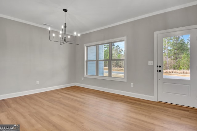 unfurnished dining area featuring visible vents, baseboards, light wood-style flooring, ornamental molding, and a chandelier