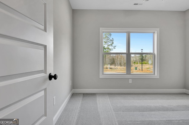 carpeted spare room with visible vents and baseboards