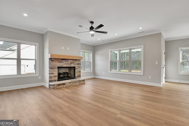 unfurnished living room with crown molding, light wood-type flooring, a fireplace, and baseboards