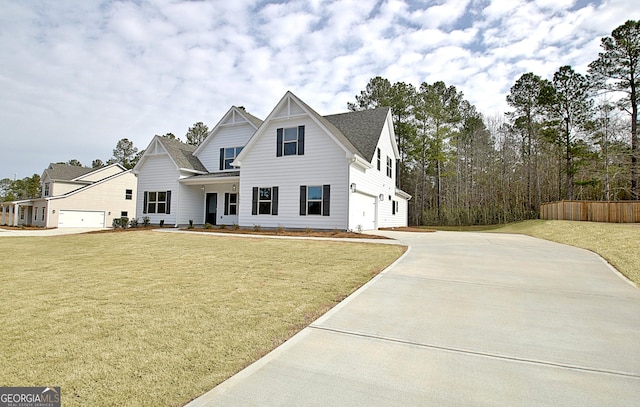 view of front of property featuring a front yard, concrete driveway, and an attached garage