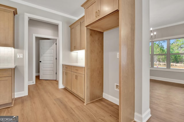 kitchen featuring light wood-type flooring, baseboards, light countertops, and backsplash