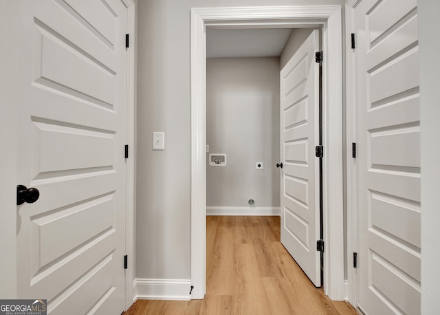 hallway with light wood-type flooring and baseboards