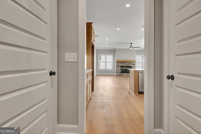 hallway with light wood-type flooring, baseboards, and recessed lighting