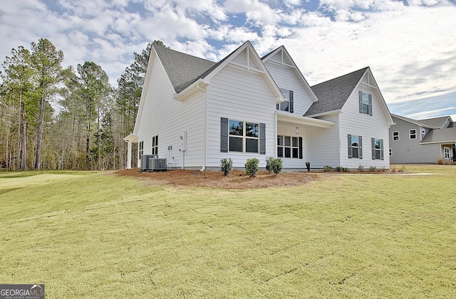 view of front of property featuring a front lawn, roof with shingles, and central air condition unit