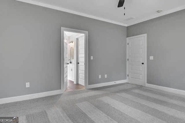 unfurnished bedroom featuring carpet, baseboards, visible vents, and ensuite bathroom