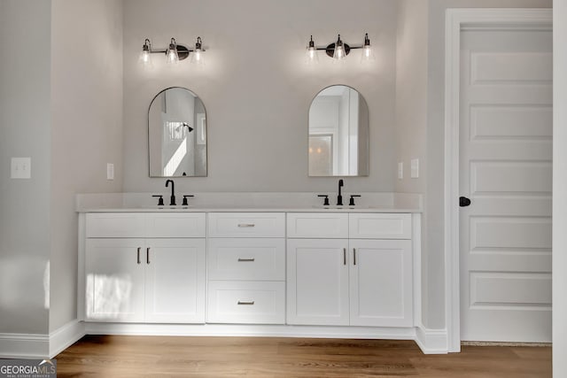 bathroom featuring double vanity, a sink, and wood finished floors