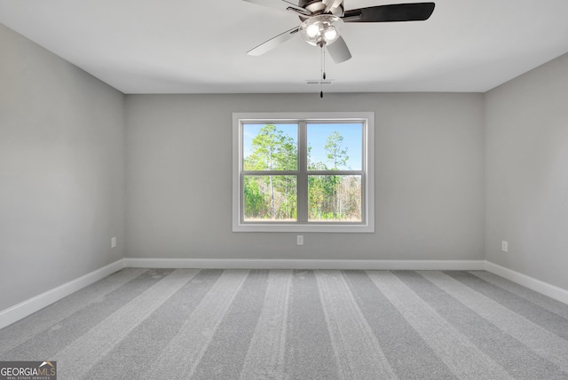 carpeted empty room featuring ceiling fan, visible vents, and baseboards