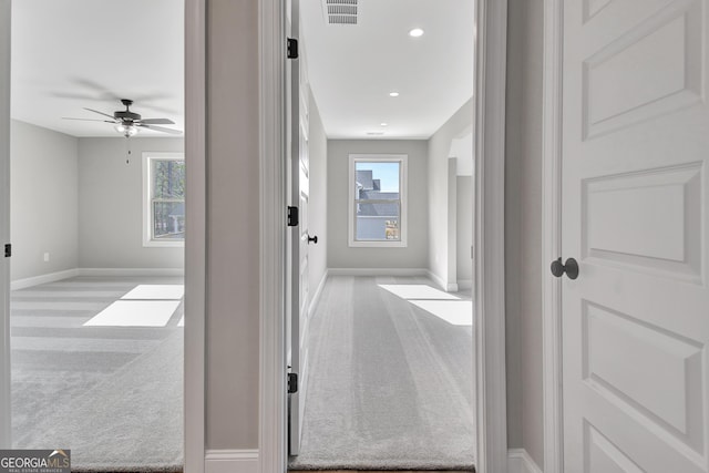 hallway with carpet floors, recessed lighting, visible vents, and baseboards