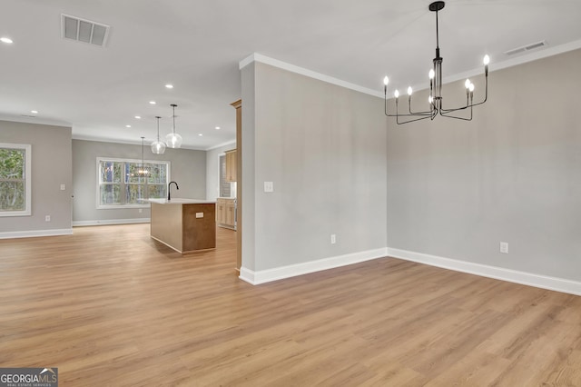 interior space featuring ornamental molding, light wood-type flooring, a sink, and visible vents