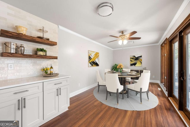 dining space featuring ornamental molding, dark wood finished floors, a ceiling fan, and baseboards