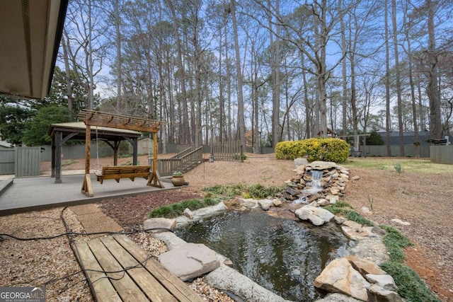 view of yard with a gazebo, a patio area, fence, and a garden pond